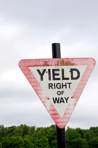 A faded triangular sign warning drivers to yield right of way