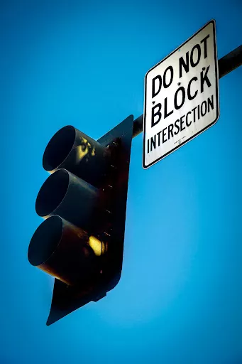 A traffic Light and sign warning not to block the intersection