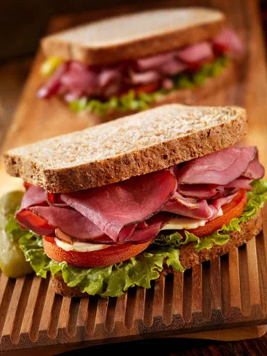 Two sandwiches on a ribbed wooden tray