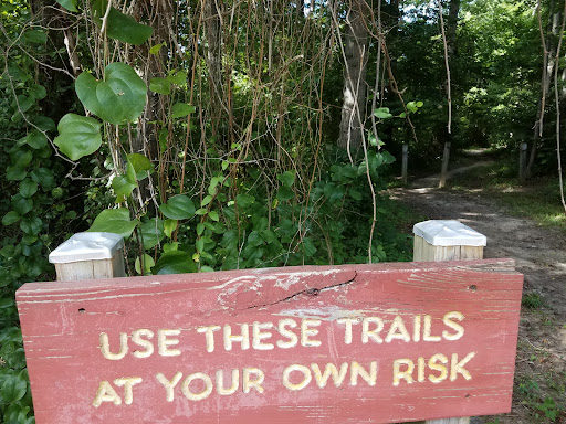 A red sign warning to use trails at one's own risk