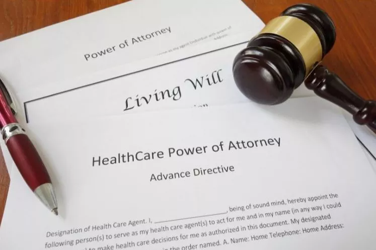 living will and medical power of attorney paperwork with gavel and pen on desk
