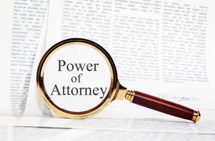 power of attorney magnified in a magnifying glass in a book