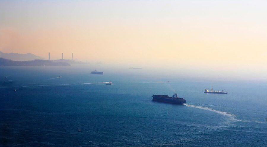 hazy sunset skies with boats in water