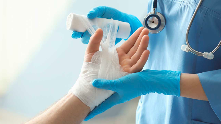 nurse wrapping hand with gauze after burn injury