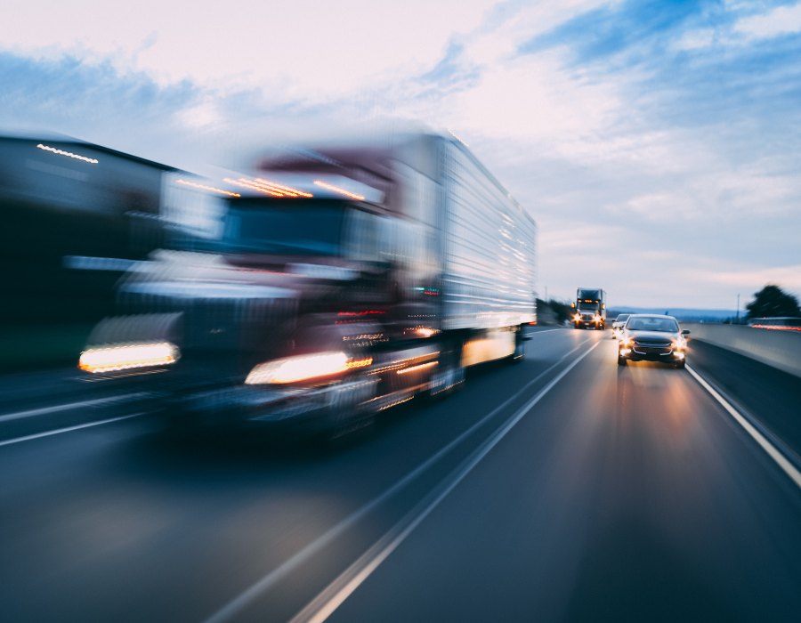 blurred image of a big rig driving on the highway