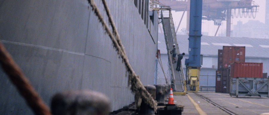 closeup of docked ship and maritime workers on ramp