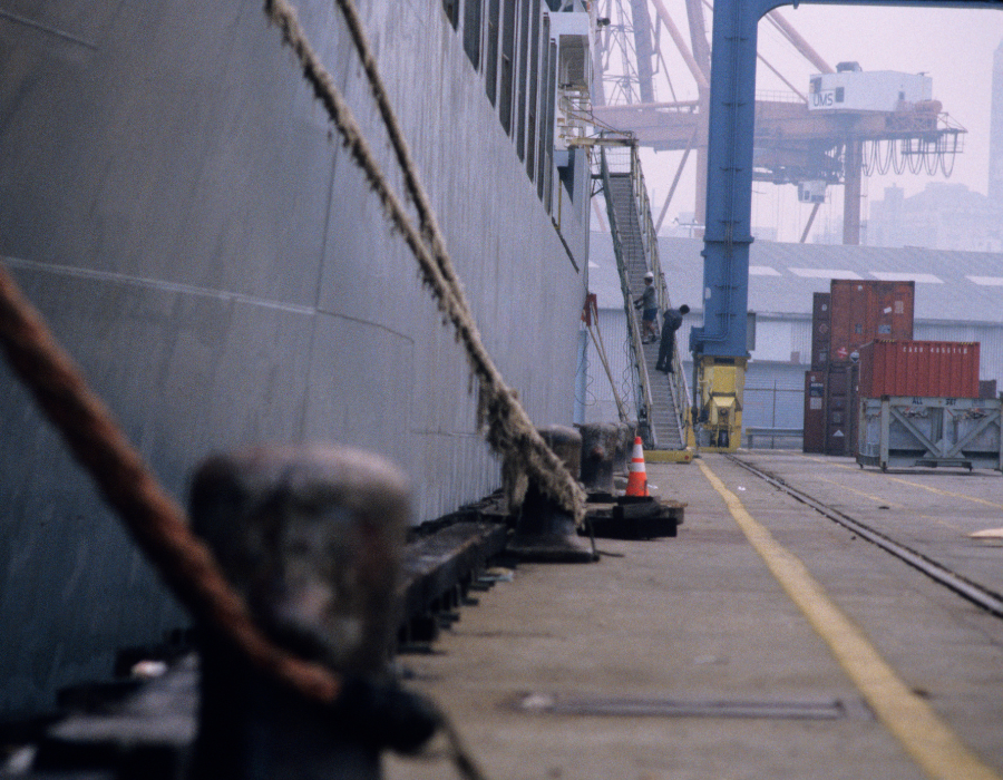 closeup of docked ship and maritime workers on ramp