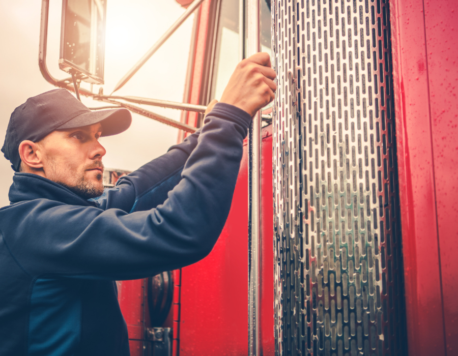 commercial truck driver next to red truck