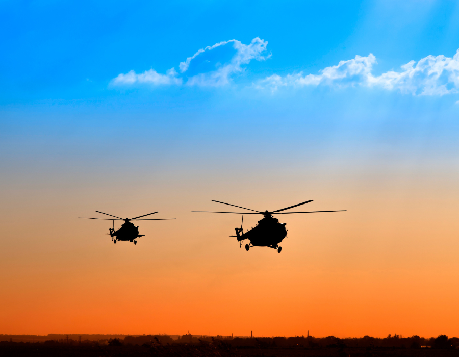 helicopters flying at sunset