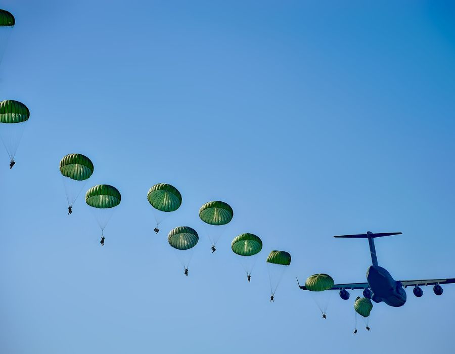 passengers using parachutes to escape crashing military plane