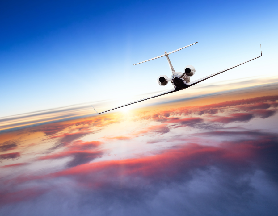 charter plane flying at sunset