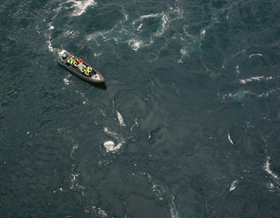 small boat in ocean with white cap ripple waves