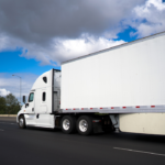 white commercial truck driving down highway