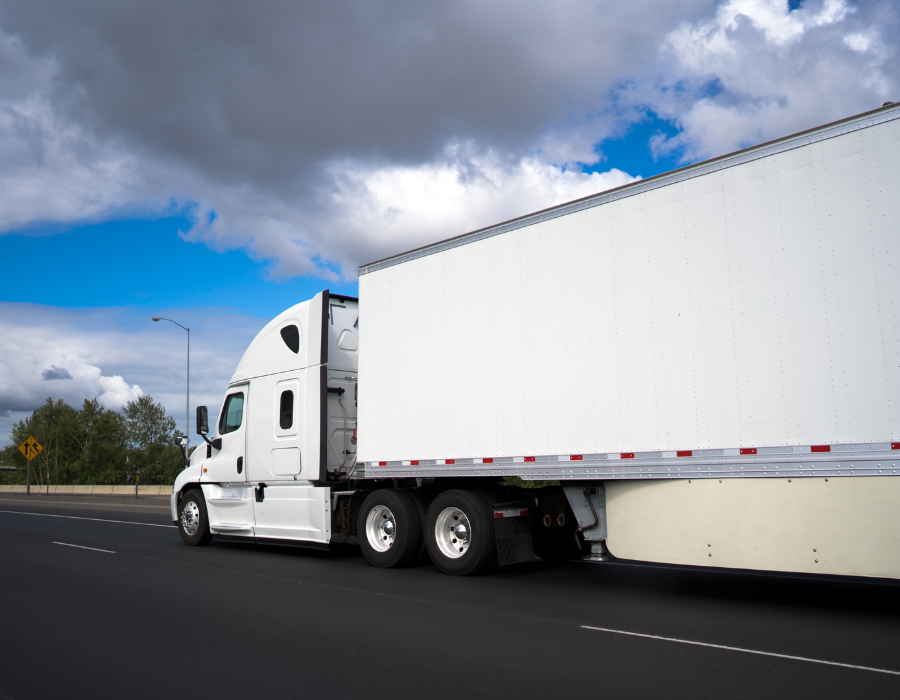 white commercial truck driving down highway