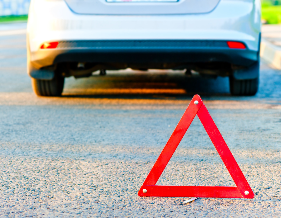 car on side of road with hazard sign