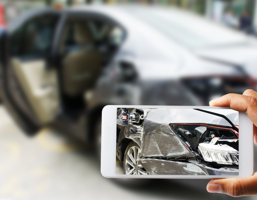 driver taking image of damaged car from a rental car accident