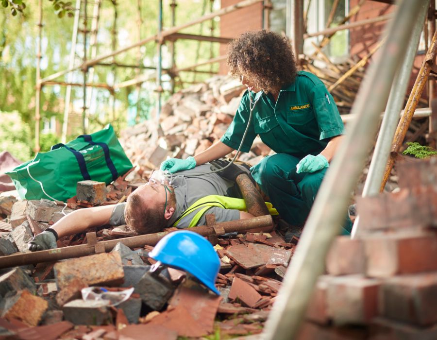 paramedic working on man in construction site rubble