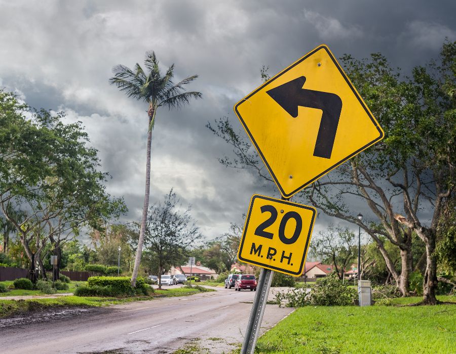 hurricane damage behind curve at 20 mph sign