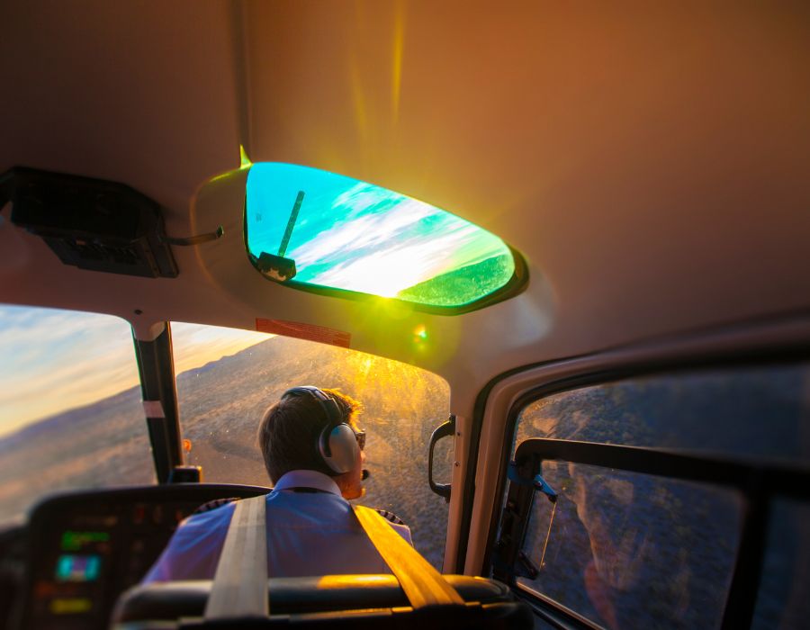 pilot of helicopter turning into the sunset