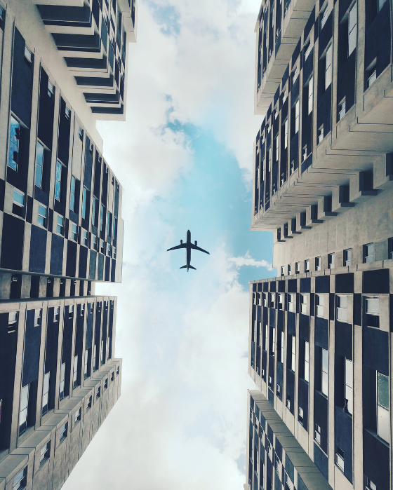 plane flying above skyscrapers