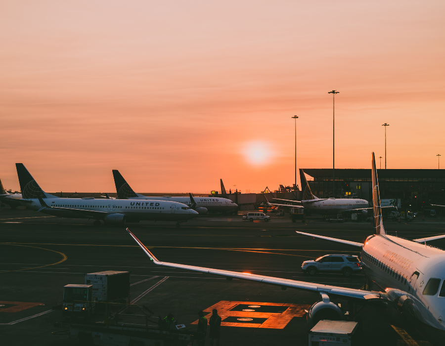 sunset over airport with united planes