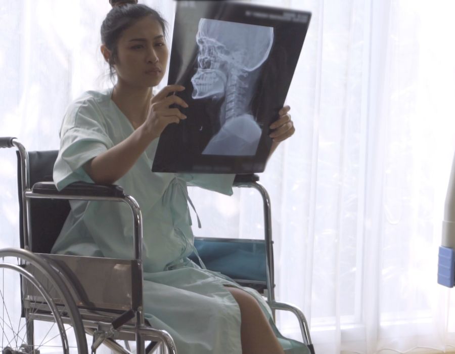 woman in wheelchair holding brain scan