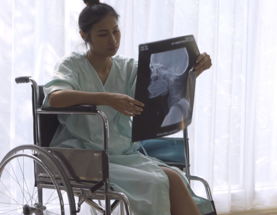 woman in wheelchair looking at brain scan