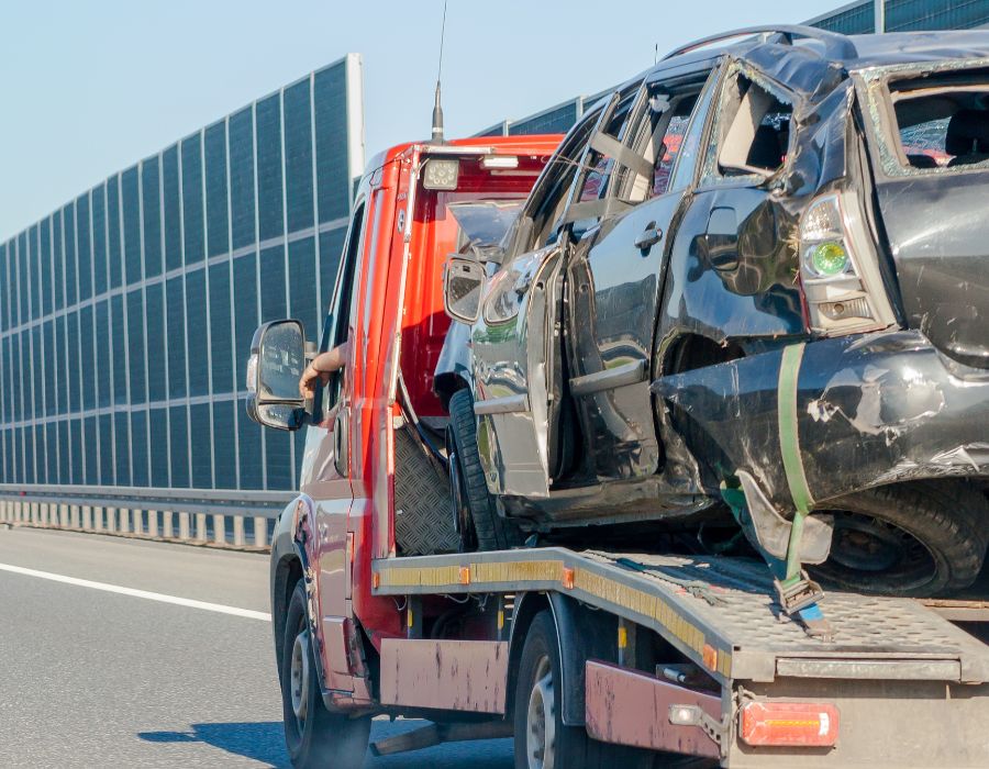 truck carrying wrecked car