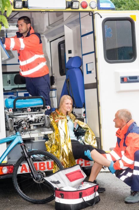 ambulance helping girl in bike accident