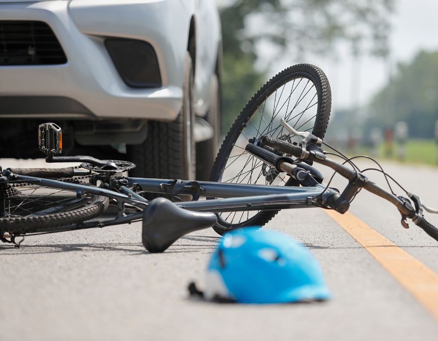bicycle and helmet on asphalt after being run over
