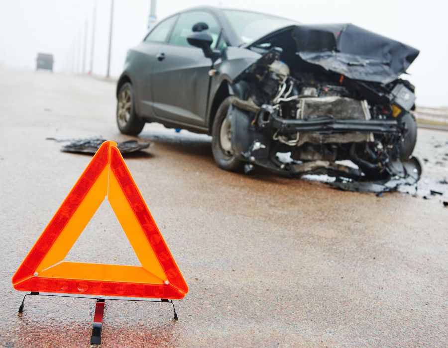 front of black car crushed on side of highway