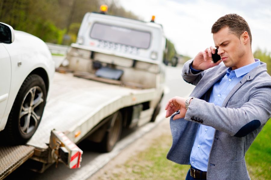 man on phone looking at watch after wreck
