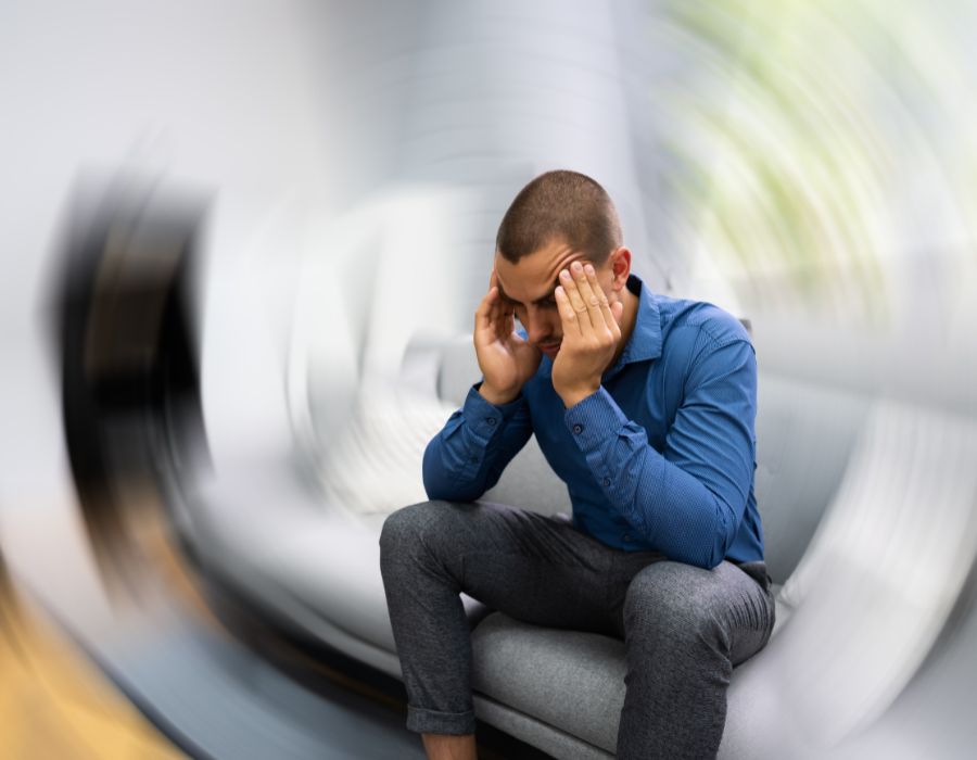 blurred background and man holding head