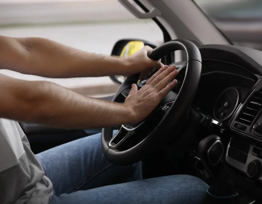 man honking car horn
