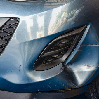 blue car with dented front bumper