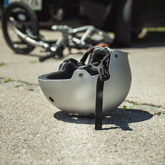 Helmet lying on asphalt. Bicycle accident concept.