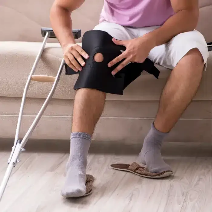 rodilla lastimada con vendaje y muleta