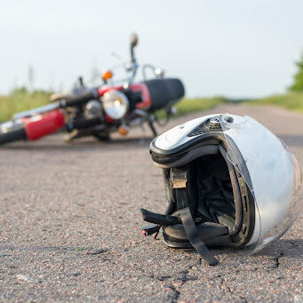 Photo of helmet and motorcycle on road, the concept of road accidents