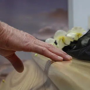 Mourner-touching-coffin Mourner touching coffin