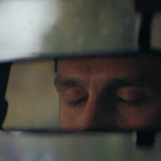Rear mirror view. Sleepy, tired, fatigued, exhausted young man closing eyes